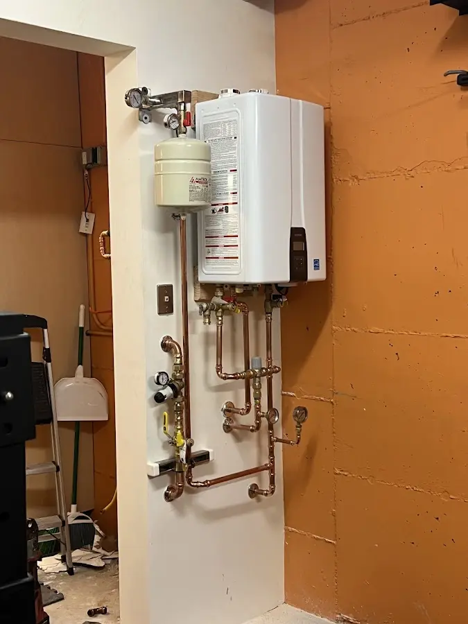 Plumbing technician inspecting water heater connections in Warrenton